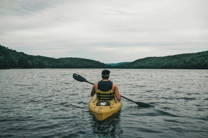 Paddler in a yellow kayak on a calm lake