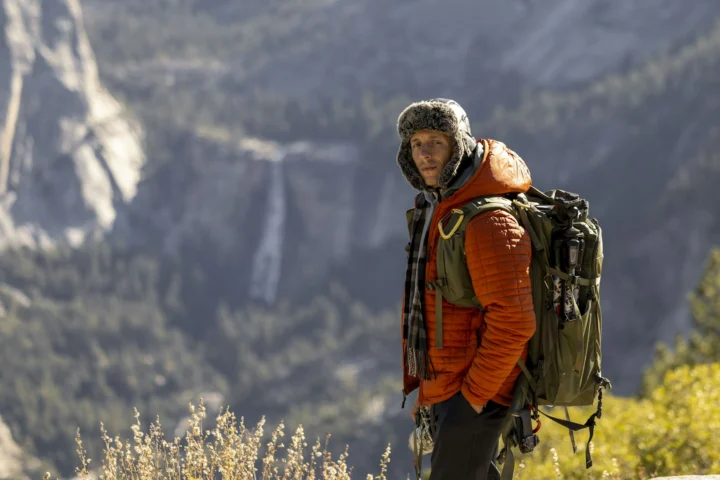 Hiker in an insulated jacket and hat above a valley in Yosemite