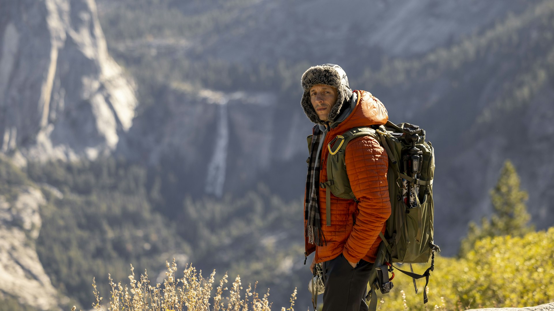 Hiker in an insulated jacket and hat above a valley in Yosemite