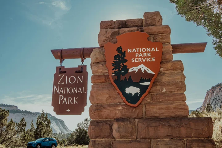 Zion National Park entrance sign with the National Park Service arrowhead