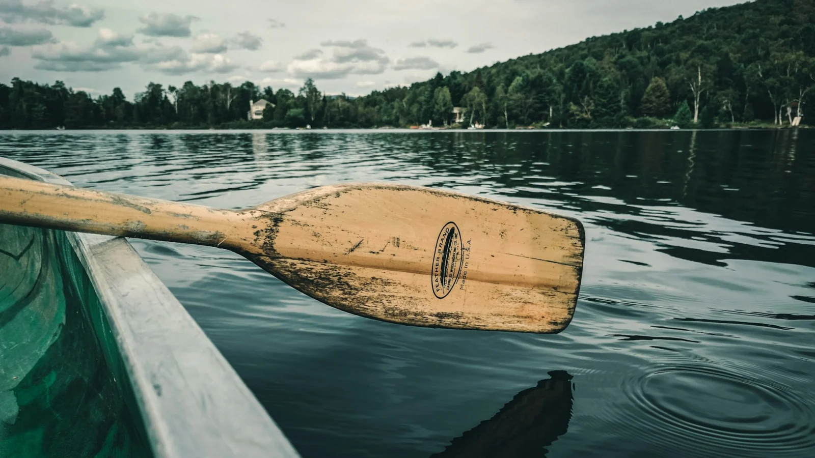 Wooden paddle resting across a canoe on a lake